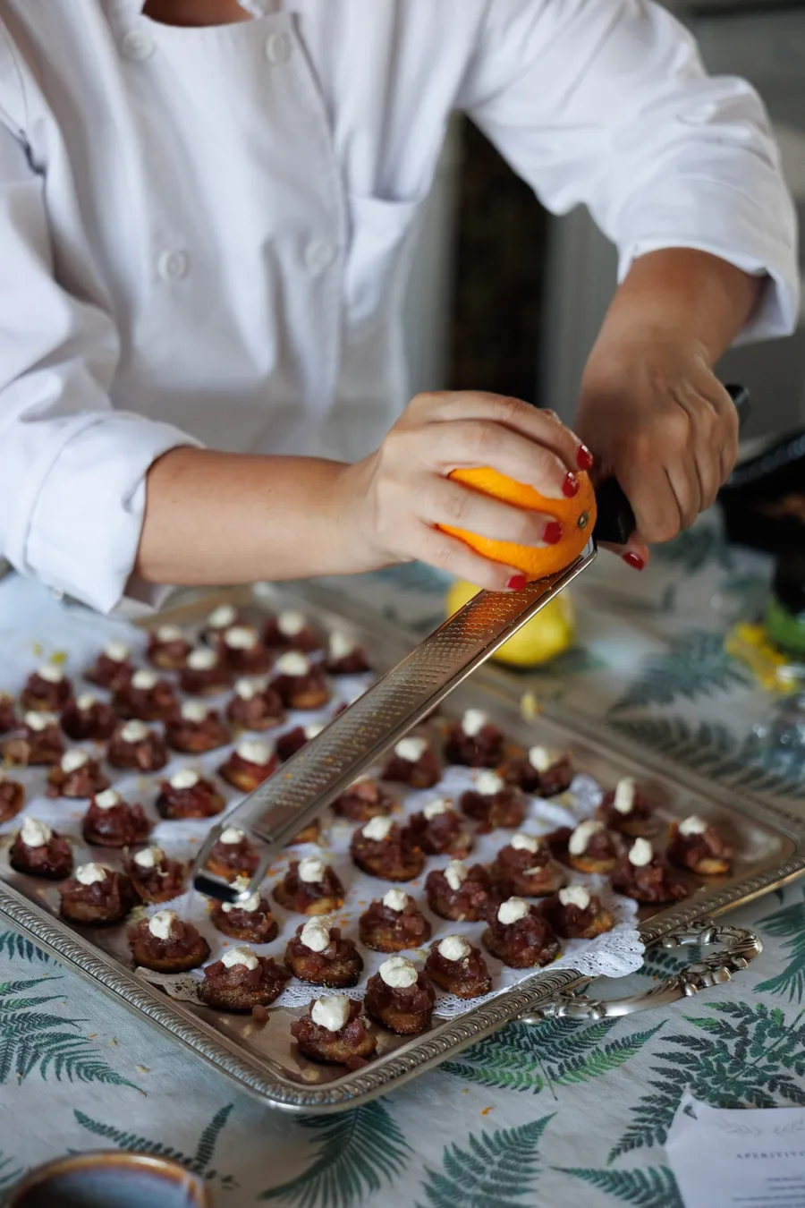 Rallando piel de naranja sobre una bandeja de canapés recién horneados.