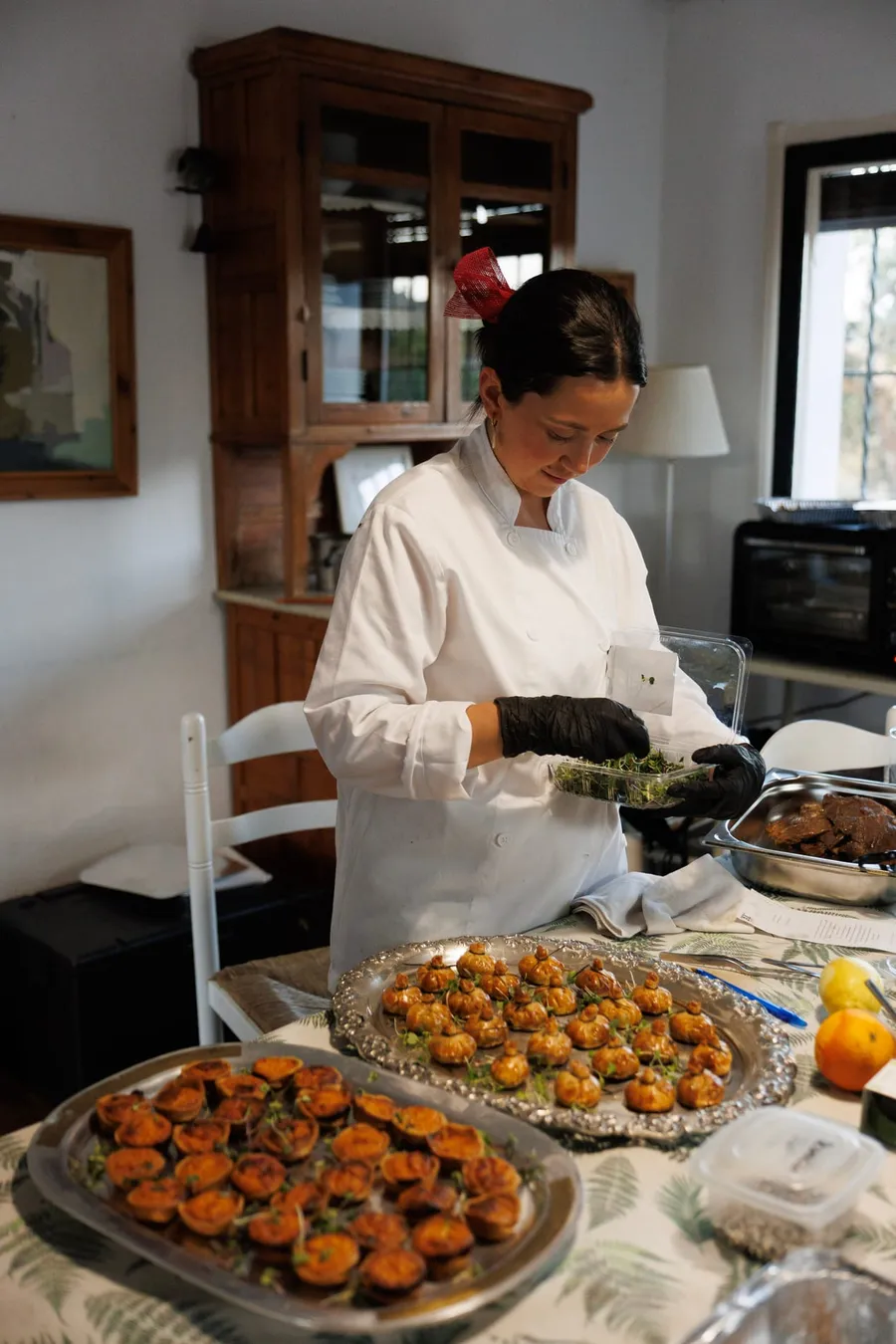 Cocinera del equipo emplatando hojaldres salados antes de servir.